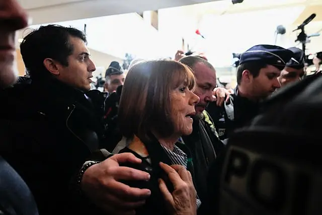 Gisele Pelicot is surrounded as she arrives at court