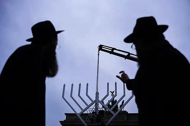 Rabbi Yehuda Teichtal, right, and Rabbi Shmuel Segal, left, watch the set-up of a giant Hanukkah Menorah by the Jewish Chabad Educational Centre in front of the Brandenburg Gate in Berlin