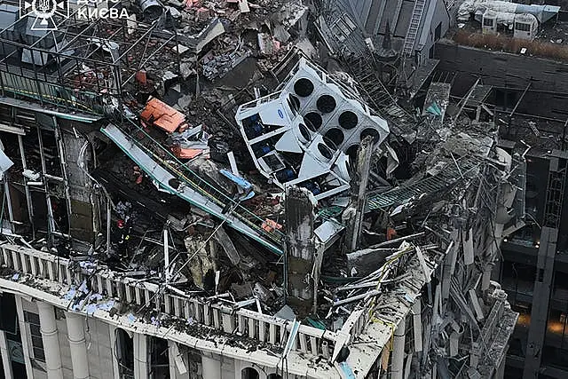 Firefighters work on the site of a damaged building 