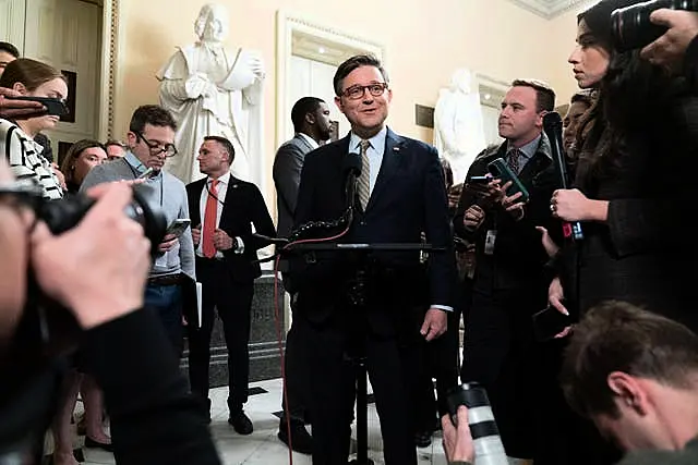 Speaker of the House Mike Johnson talks to reporters after the House approved the funding bill