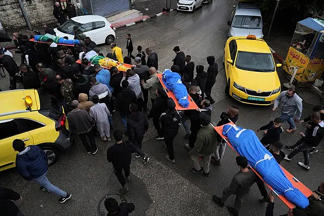 Mourners carry the bodies of four Palestinians killed by an Israeli airstrike in the West Bank city of Tulkarem