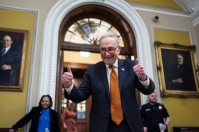 Chuck Schumer celebrating by holding two thumbs up as the Senate begins voting on the government funding bill just in time to meet the midnight deadline