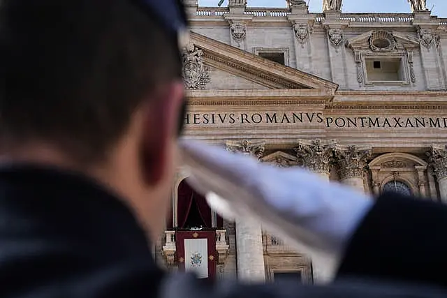 A Vatican gendarmerie officer salutes as Pope Francis prepares to deliver the Urbi et Orbi (Latin for ‘to the city and to the world’ ) Christmas Day blessing from the main balcony of St Peter’s Basilica at the Vatican