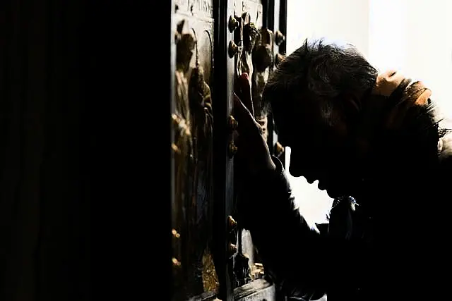 A man stops in prayer as he walks through the Holy Door of St Peter’s Basilica at the Vatican