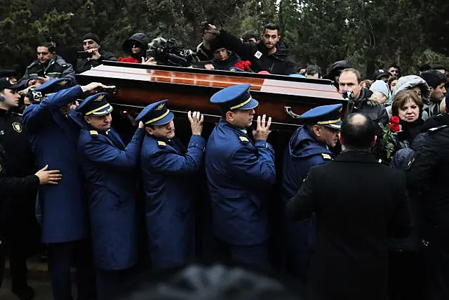 Pilots carry a coffin during a funeral of the crew members of the Azerbaijan Airlines plane