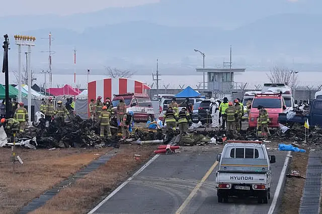 Rescue team members work at the site of the plane crash in South Korea