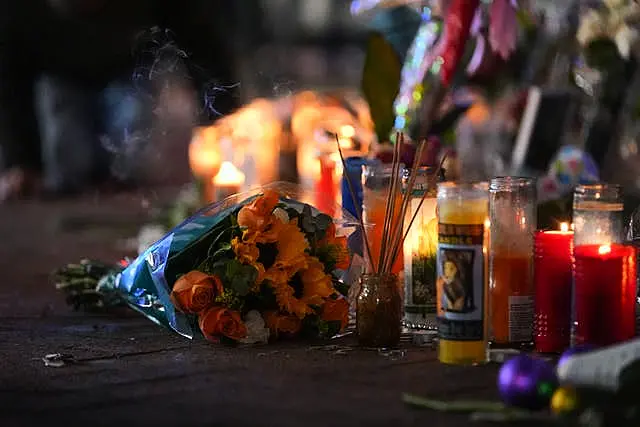 Flowers lie next to candles at a memorial for the victims of the attack