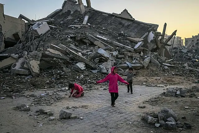 Palestinian children play next to a building destroyed by Israeli army strikes