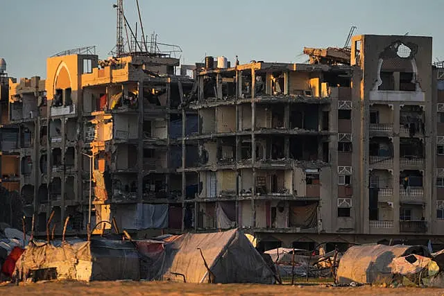 Tents for displaced Palestinians are set up next to buildings damaged by Israeli army strikes in the central Gaza Strip town of Khan Younis