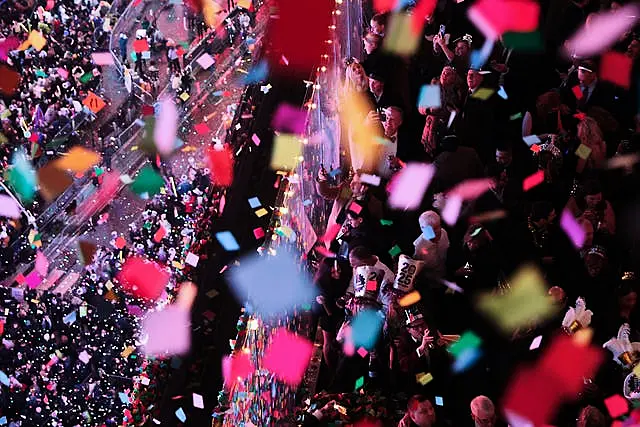 Revelers watch and record as confetti falls over Times Square 