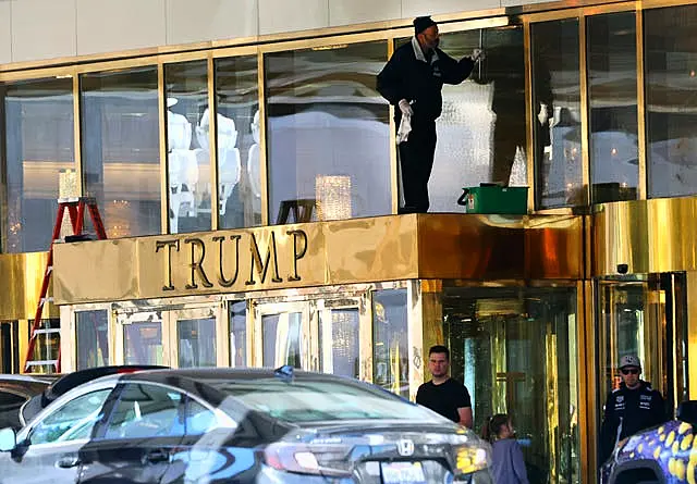 A worker cleans glass windows at Trump International Hotel