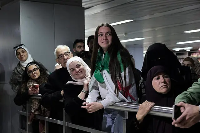 People wait to receive their relatives at the arrival terminal at Damascus airport