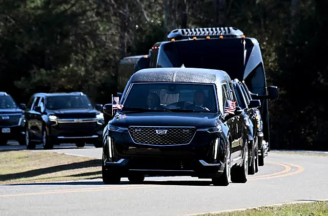 The motorcade with the hearse carrying the flag-draped coffin