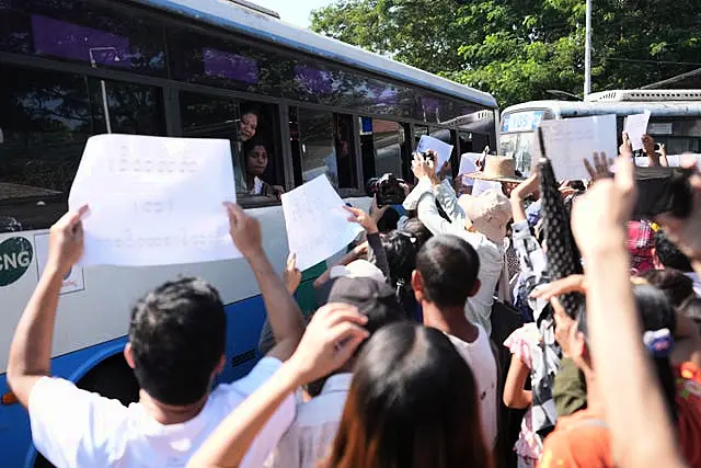 A bus carrying released prisoners is welcomed by family members