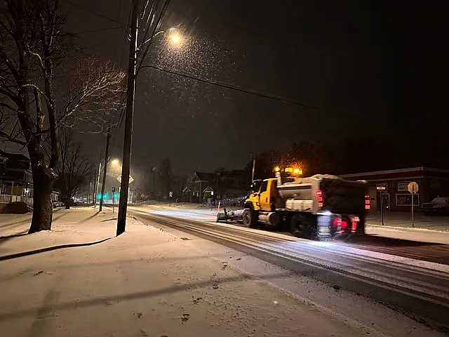 A snowplough travels along a snowy road