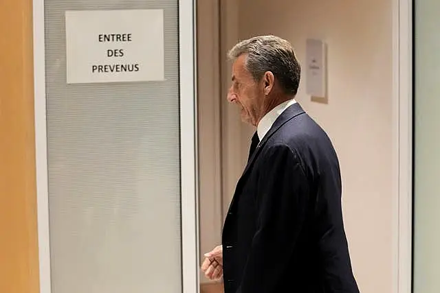 Former French President Nicolas Sarkozy enters the courtroom 