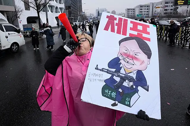 A protester blows a vuvuzela during a rally 