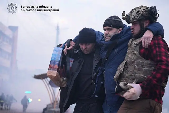 Paramedics carry an injured man into an ambulance 