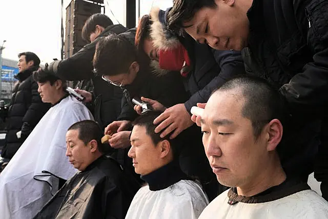 Supporters of impeached South Korean President Yoon Suk Yeol have their heads shaved as they attend a rally to oppose his impeachment near the presidential residence in Seoul