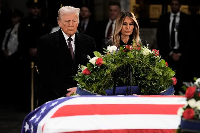 President-elect Donald Trump and his wife Melania Trump pause at the flag-draped casket of former president Jimmy Carter as he lies in state in the rotunda of the US Capitol in Washington 