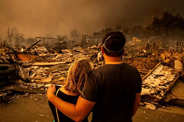 A couple return to their fire-damaged home after the Eaton fire swept through the area in Altadena 