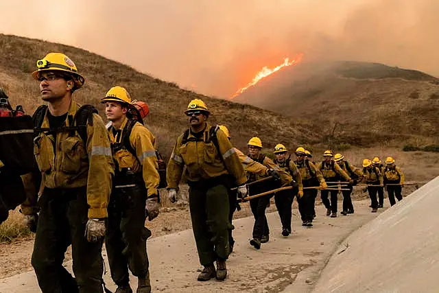 Fire crews walk as they battle the Kenneth Fire in the West Hills section of Los Angeles 