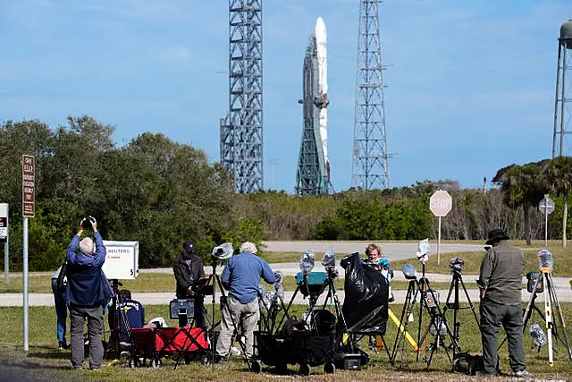 Photographers at the Cape Canaveral Space Force Station with the New Glenn rocket in the background