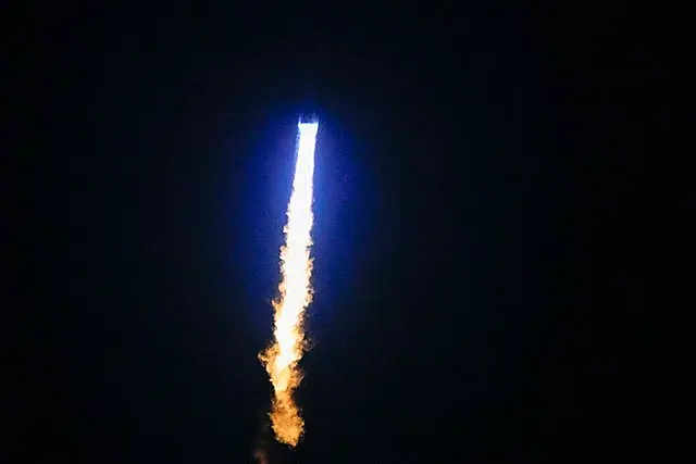 The New Glenn rocket heading into space in dark night sky