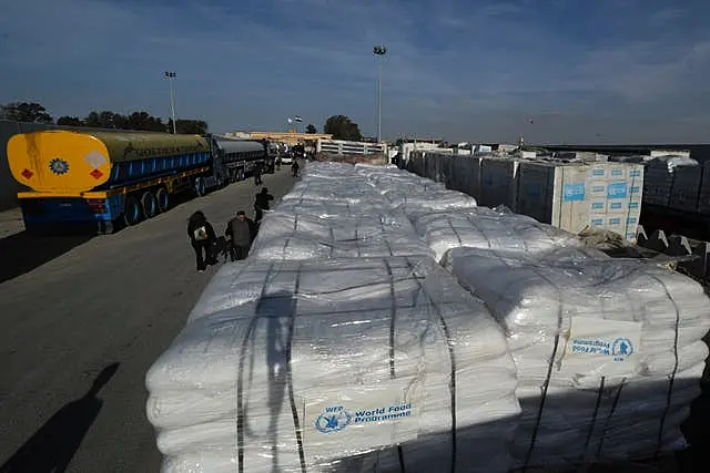 Trucks carrying humanitarian aid line up to cross the Rafah border crossing between Egypt and the Gaza Strip