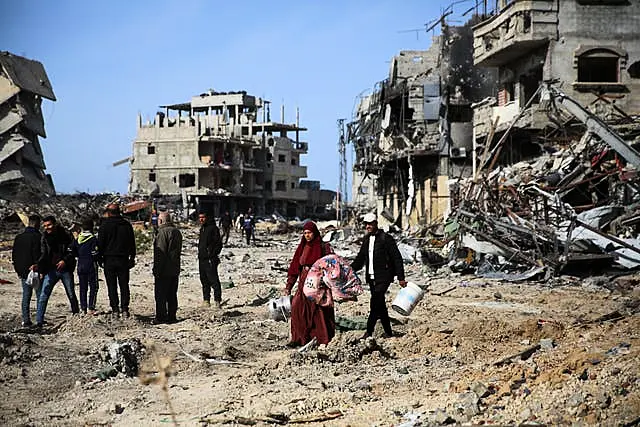 Palestinians inspect the destruction caused by the Israeli air and ground offensive in Rafah, as a ceasefire deal between Israel and Hamas went into effect 