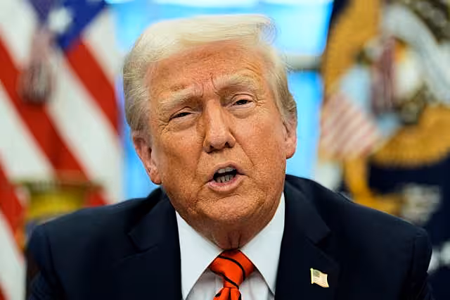 President Donald Trump speaks with reporters as he signs an executive order in the Oval Office at the White House