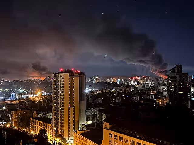 A fumaça sobe acima do horizonte da noite em Kyiv
