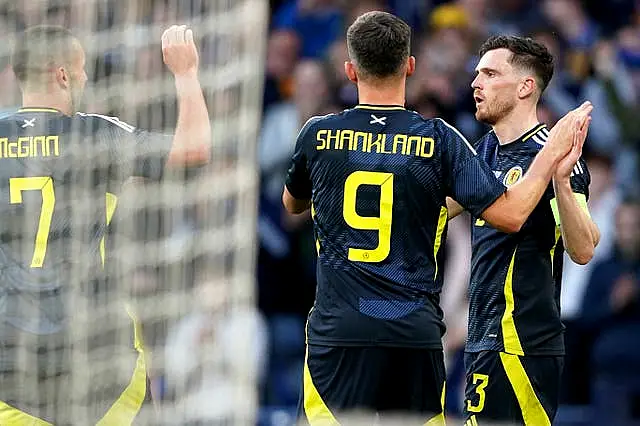 John McGinn, Lawrence Shankland and Andy Robertson, left to right, celebrate Scotland’s first goal against Finland