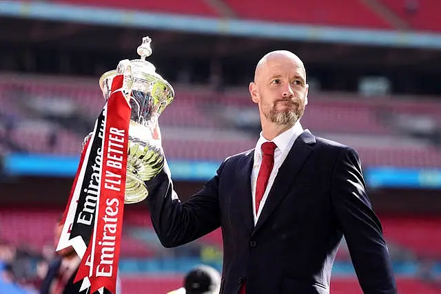 celebrates with the trophy after winning the Emirates FA Cup final at Wembley in May