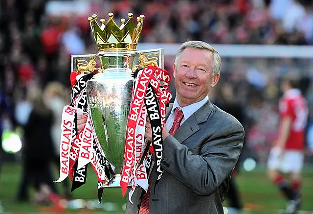 Sir Alex Ferguson smiles as he lifts the Premier League trophy