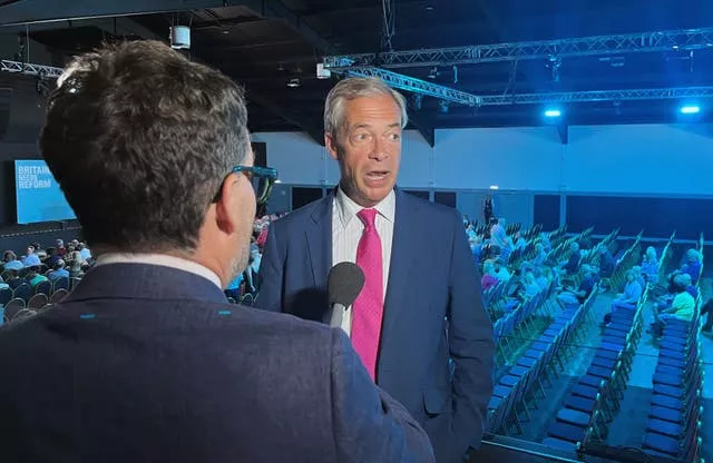 Nigel Farage speaks to a man with a microphone