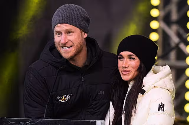 Harry and Meghan in winter coats and hats at the Invictus Games in Vancouver