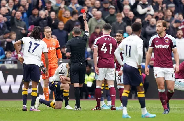 Everton’s Michael Keane, third left, is shown a red card by referee Michael Oliver, centre left