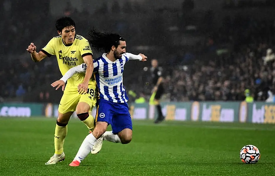 Arsenal’s Takehiro Tomiyasu, left, and Brighton's Marc Cucurella battle for the ball