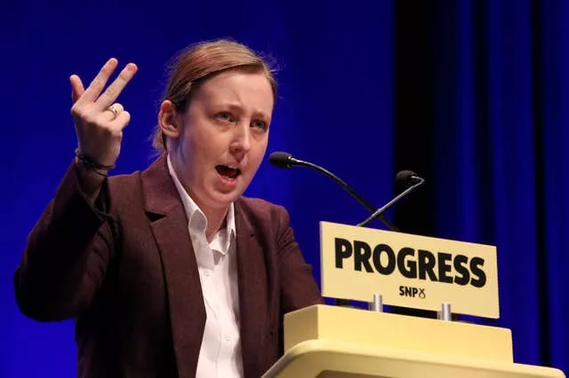 Mhairi Black during a speech at the SNP conference behind a lectern reading 'progress' 