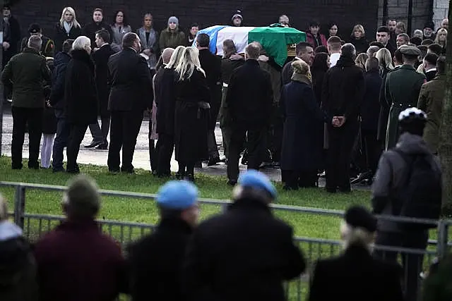 The coffin of Private Sean Rooney is carried into Holy Family Church