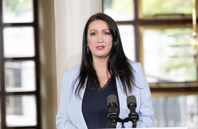 Emma Little-Pengelly standing at a microphone