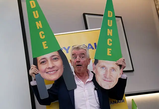 Ryanair chief executive Michael O’Leary holding pictures of politicians with dunces' caps on