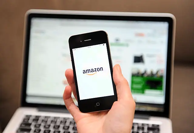 A woman uses a smartphone to browse the Amazon website