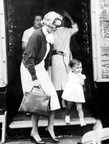 Princess Grace holds the hand of her daughter, Princess Caroline, during a shopping trip in the Avenue des Moulins in Monte Carlo. 