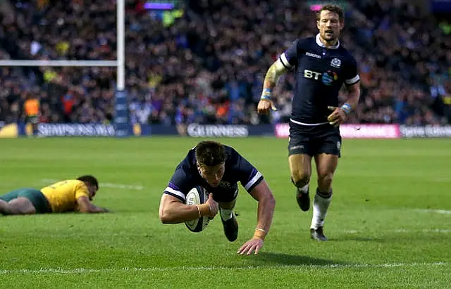 Scotland’s Huw Jones dives over the line to score a try with an Australian player on the ground behind him