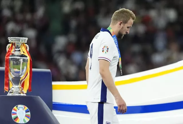 Harry Kane walks past the Euro 2024 trophy 