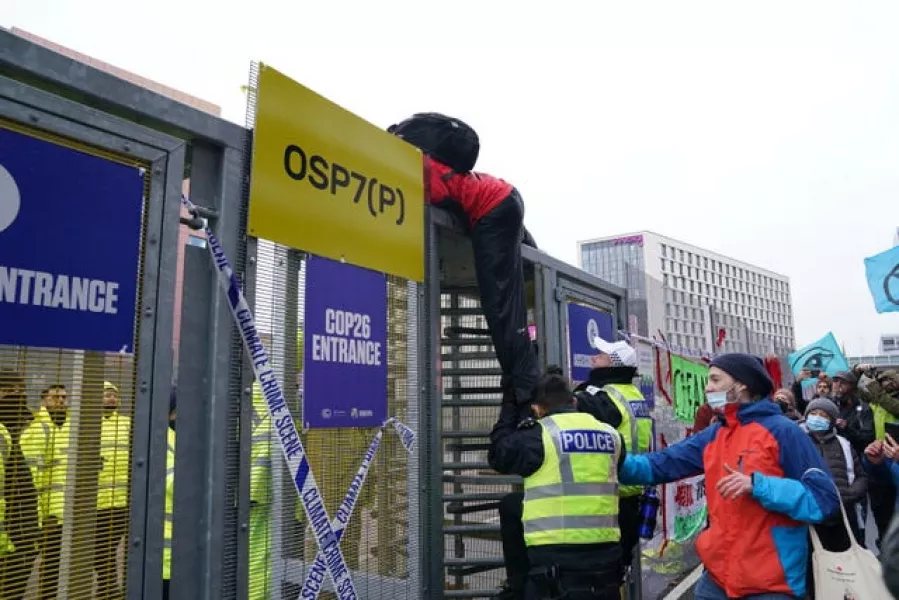 A protester tries to climb over the fence into Cop26 (Andrew Milligan/PA)
