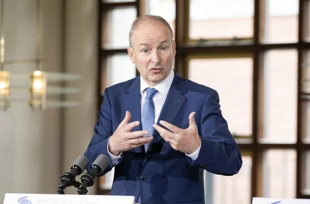 Micheal Martin gesturing behind microphones