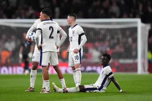 Bukayo Saka sits on the Wembley turf